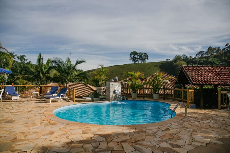 Piscina ao ar livre cercada por jardins